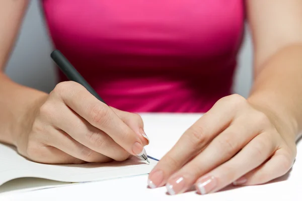 Las manos de la mujer sosteniendo una pluma escribiendo un texto — Foto de Stock