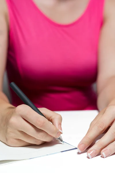 Las manos de la mujer sosteniendo una pluma escribiendo un texto — Foto de Stock