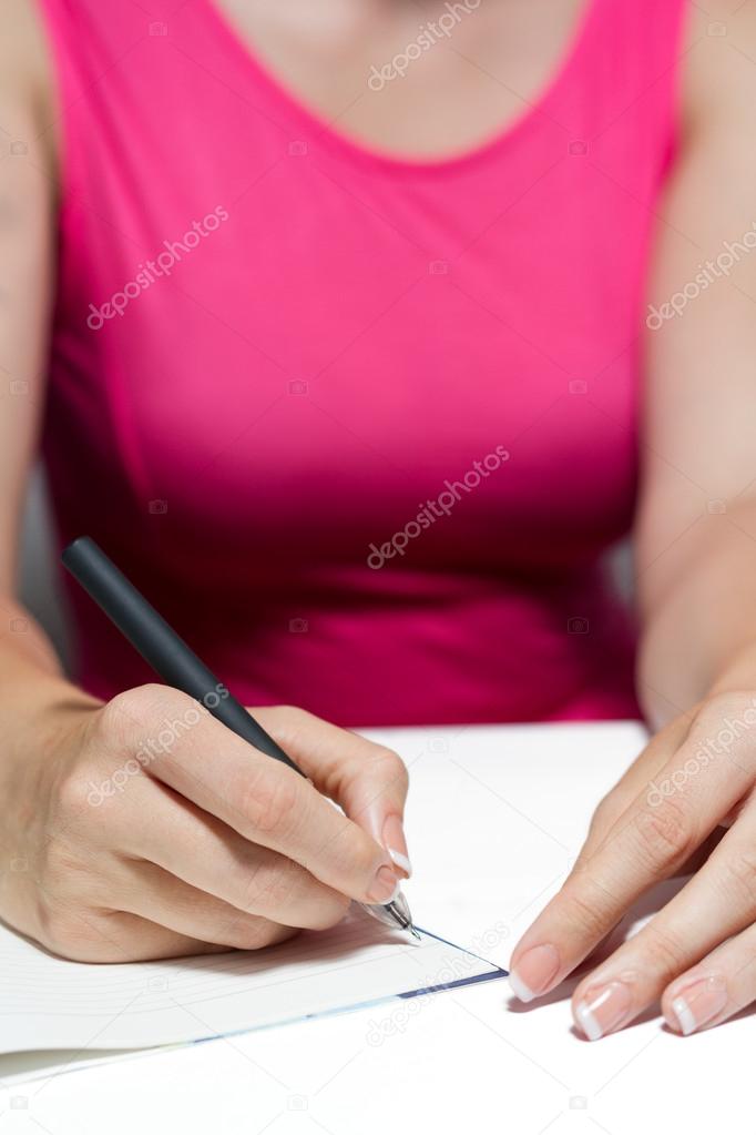 Woman's Hands Holding A Pen Writing A Text