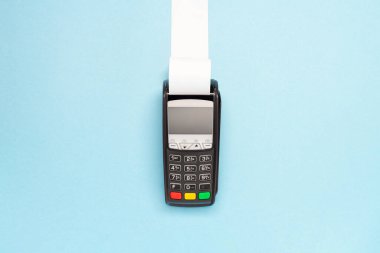 Mavi arka planda uzun kasiyer bandı olan pos terminal. alışveriş teması