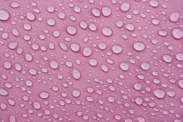 Wassertropfen auf rosa Regenschirm — Stockfoto