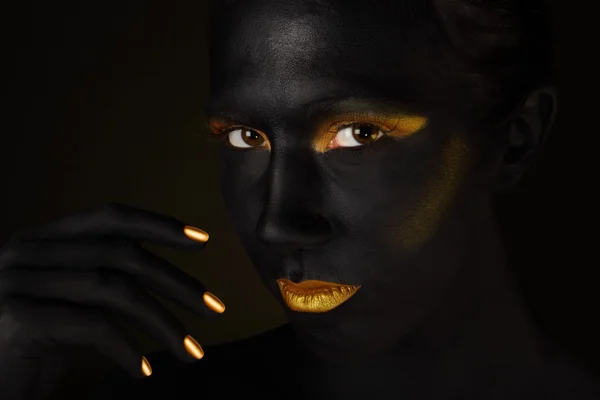 Mooie donkere gezicht geïsoleerd op zwart met oranje make-up — Stockfoto