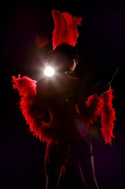 Burlesque dancer with red plumage and short dress, black background clipart
