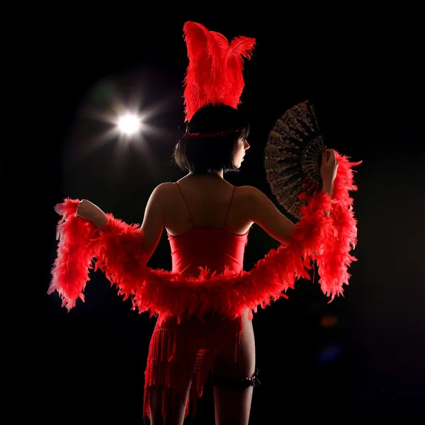 Burlesque danseres met rode verenkleed en korte jurk, zwarte achtergrond — Stockfoto