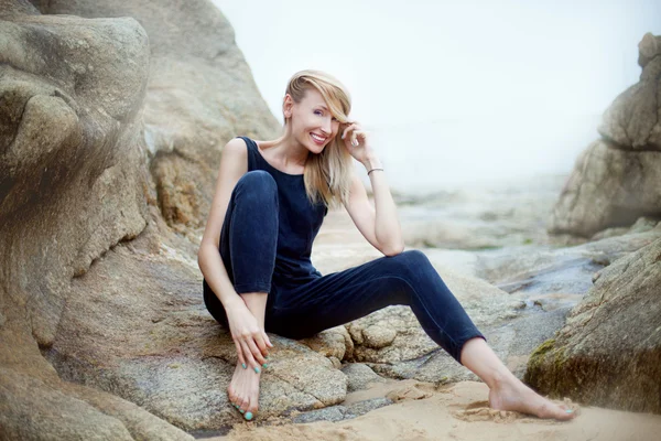 Belle femme blonde posant sur des pierres — Photo