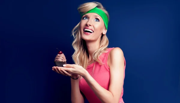 Smiling blonde woman with cupcake. — Stock Photo, Image