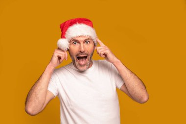 Noel Baba şapkası takan, kameraya bakıp komik suratlar yapan neşeli sakallı adamın portresi. Xmas zamanı. Noel satış konsepti. Bir sürü kopyalama alanı