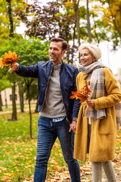 一对恋爱中的成年夫妇的画像 一个英俊的男人和一个漂亮的女人一起在阳光灿烂的公园里散步 秋季调色图像 — 图库照片