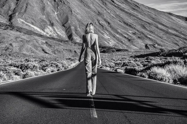 ジーンズで女性のトップレス旅行者離れて野生の山の風景の上に通りを歩いてください バックビュー 欲望旅行の概念 観光客だ フェミニスト — ストック写真