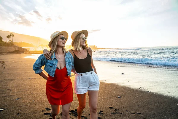 Dvě Šťastné Blonďaté Bělošky Slunečních Brýlích Letních Kloboucích Procházející Pláži — Stock fotografie