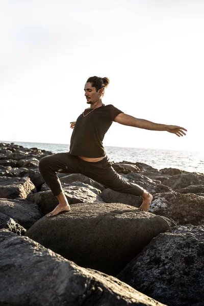 漂亮的瑜伽老师正在岩石上练习 日落时分 人运动 伸展身体 Pranayama 心神不宁默念 — 图库照片