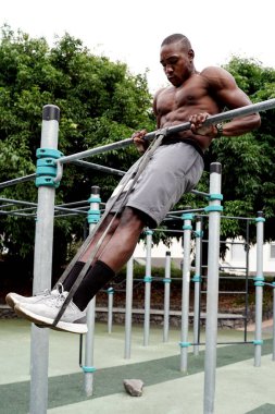 Genç yakışıklı sporcu parktaki barlarda jimnastik yapıyor. Açık spor salonu. Sağlıklı bir yaşam tarzı. Spor. Hobi olarak. Kas gücü