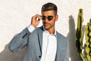 Modern businessman. Confident young man in fashionable suit and sunglasses posing outdoor, relaxing. Handsome guy, elegant style. Influencer. clipart