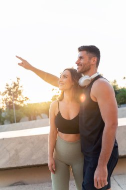 Güçlü bir çift. Dışarıda egzersiz yaptıktan sonra spor kıyafetleri içinde dinlenen yakışıklı erkek ve güzel kadın. Fitness çifti. Sağlıklı yaşam tarzı.