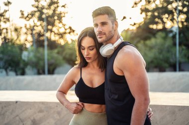 Güçlü bir çift. Dışarıda egzersiz yaptıktan sonra spor kıyafetleri içinde dinlenen yakışıklı erkek ve güzel kadın. Fitness çifti. Sağlıklı yaşam tarzı.