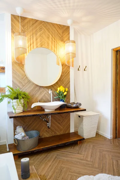 円形の鏡がその上にかかっている木製のカウンターに白いシンク 浴室のインテリア 新鮮な花だ デザイン — ストック写真