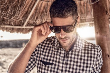 Plajda poz veren yakışıklı genç bir İtalyan, şık bir gömlek giymiş, yaz zamanı. Bir sürü kopyalama alanı