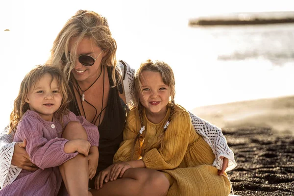 可爱的小妹妹们和她的母亲在外面玩耍 女人和她的女儿们在阳光灿烂的海滩上休息 快乐的家庭母亲节快乐 夏天的感觉 — 图库照片