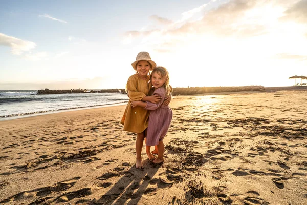 孩子们在海滩上玩耍 日落时小姐妹们在海滨玩得很开心 家庭暑假让人兴奋 大量的复制空间 — 图库照片