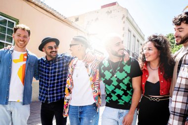 Modaya uygun bir grup mutlu çok kültürlü arkadaş birlikte eğleniyor, gülümsüyor ve sokaklarda yürüyor. Arkadaşlık. Gerçek insanların duyguları. Turizm. Seyahat.