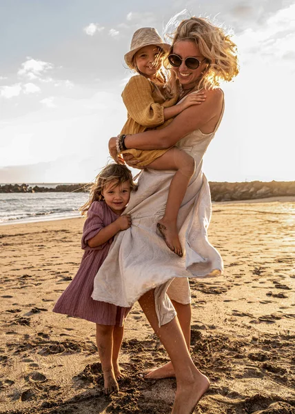 可爱的小妹妹们和她的母亲在外面玩耍 女人和她的女儿们在阳光灿烂的海滩上休息 快乐的家庭母亲节快乐 夏天的感觉 — 图库照片