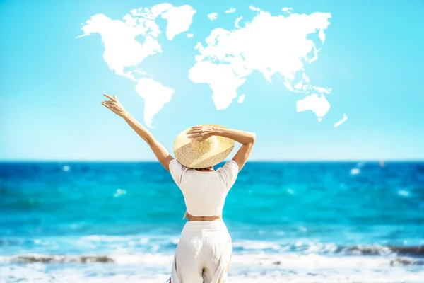 一个女人戴着草帽 在海滩享受阳光的概念性照片 后视镜蓝色天空中的世界地图形状的云 大量的复制空间 — 图库照片