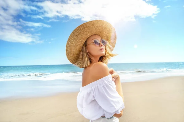 穿着夏草帽 戴着时髦太阳镜 走在海滩上悠闲自在的金发美女形象 度假的激情 阳光灿烂的日子 旅游概念 大量的复制空间 — 图库照片