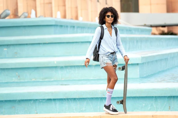 Молода Жінка Афро Зачіскою Позує Міській Вулиці Несучи Скейтборд Одягнений — стокове фото