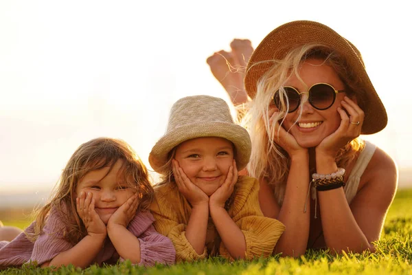 Happy Woman Relaxing Her Two Daughters Outdoor Meadow Lying Smiling — ストック写真