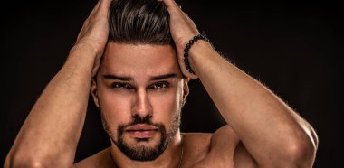 Kahverengi gözlü, seksi, sakallı ve kameraya bakan adamın güzel portresi. Siyah stüdyo geçmişi. Erkek modeli. 