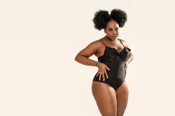 Full-length photo of beautiful plus size dark skinned woman posing on light  gray, wearing black fashionable swimsuit. Body positive, conscious concept.  photo – Plus size model Image on Unsplash