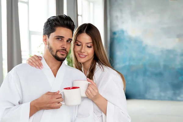 Young Happy Couple Drinking Coffee Morning White Bathrobes Enjoying Slow — Stok fotoğraf