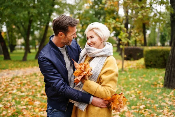 快乐的情侣们在金秋公园的室外合影 看着彼此 面带微笑 妻子和丈夫恋爱了真实的人的情感概念 — 图库照片