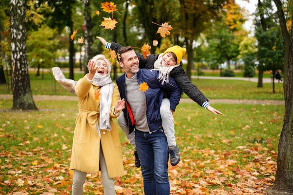 秋の公園で一緒に楽しみ 黄金の葉を投げ 笑っている幸せなお母さん お父さんと息子 子供時代 本当の人々の感情の概念 — ストック写真