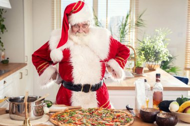 Gerçek Noel Baba evde İtalyan pizzası yapıyor. Noel konsepti.