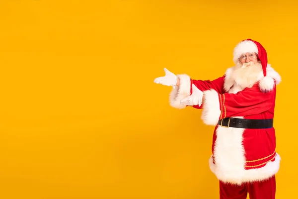 Щасливий Санта Клаус Показує Пусте Рекламне Місце Жовтому Тлі Студії — стокове фото
