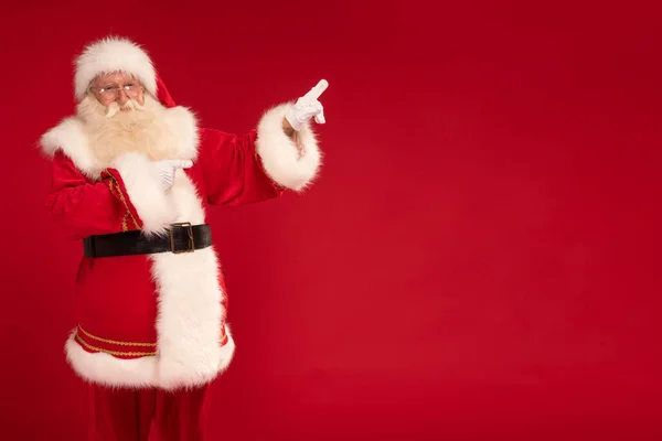 Щасливий Бородатий Санта Клаус Вказує Порожнє Червоне Тло Студії Різдвом — стокове фото