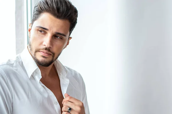 Portrait of successful, elegant man wearing white shirt, looking away. Handsome male model with beard. Closeup photo