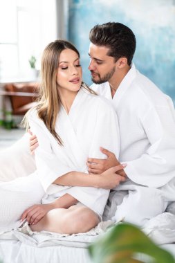 Romantik genç çift sabahlarını yatakta geçirir. Sevgililer gününün tadını çıkaran iki güzel insan. Rahat ol. Randevu. Sevgi. Gerçek insan yaşam tarzı.