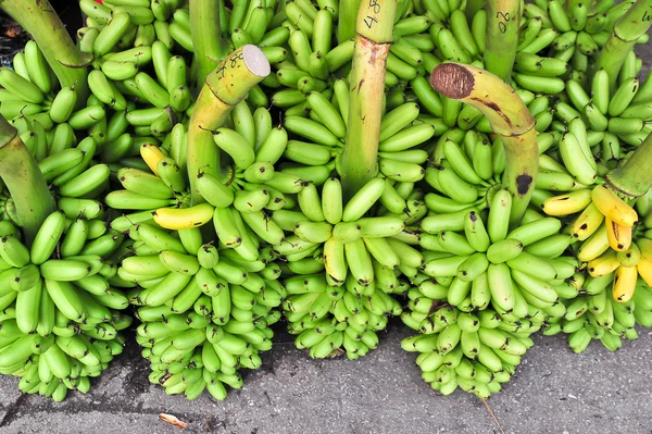 Green banana on floor in market, thailand — Stock Photo, Image