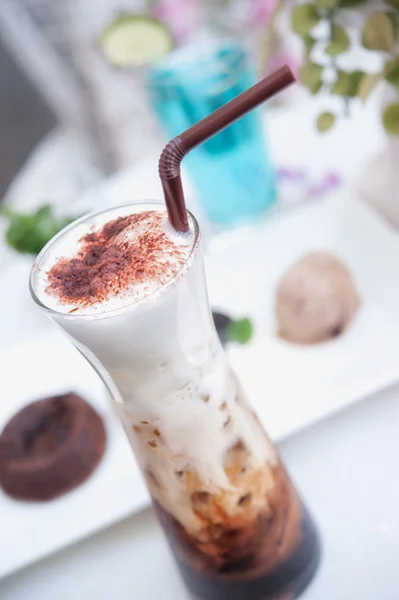 Вкусный кофе со льдом и пеной на столе — стоковое фото