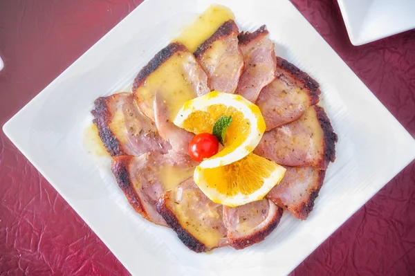 Slice grilled steak meat with lemon sauce on white dish — Stock Photo, Image