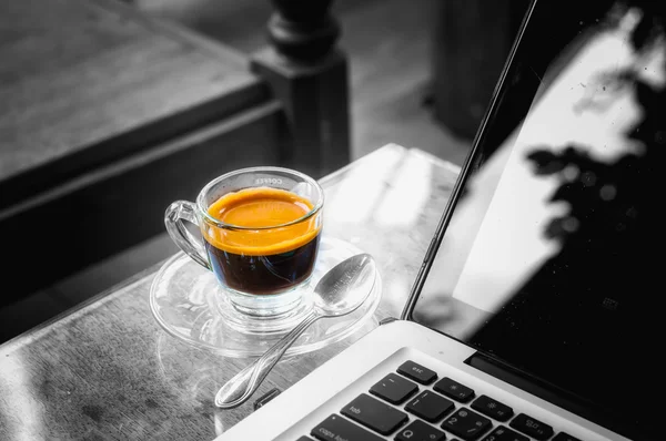 Laptop en warme kop koffie op houten tafel, bedrijfsconcept — Stockfoto
