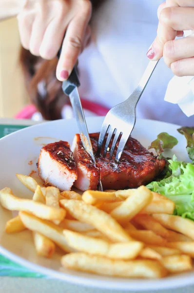 Alguien comiendo filete a la parrilla en un plato blanco —  Fotos de Stock