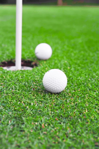 Dos pelotas de golf en campo de golf putting green — Foto de Stock