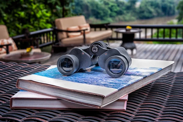 Binocolo con il libro sul tavolo in rattan — Foto Stock