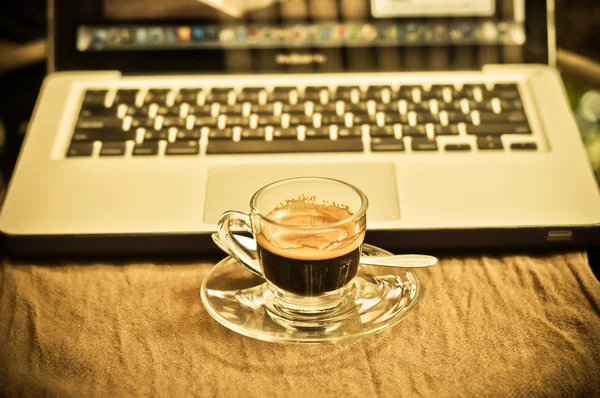 コーヒーカップとビジネス用ノートパソコン. — ストック写真