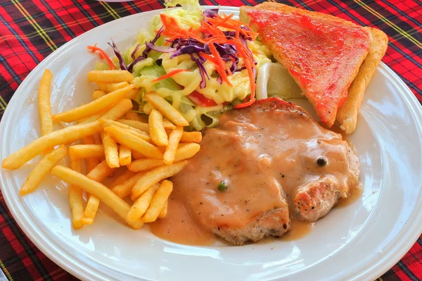 Жареный стейк, картофель фри, тосты и салат — стоковое фото