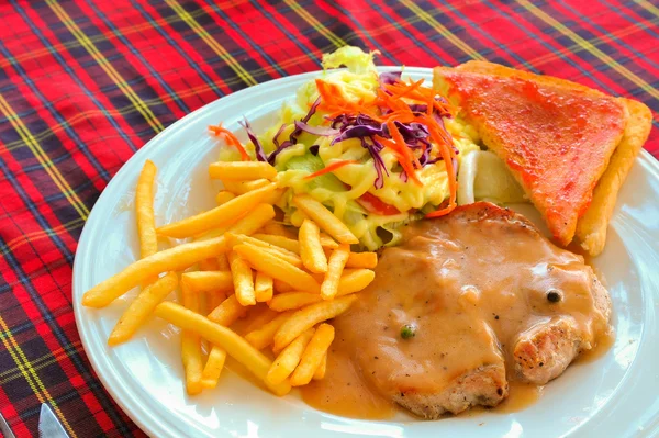 Bife grelhado, batatas fritas, torradas e salada — Fotografia de Stock