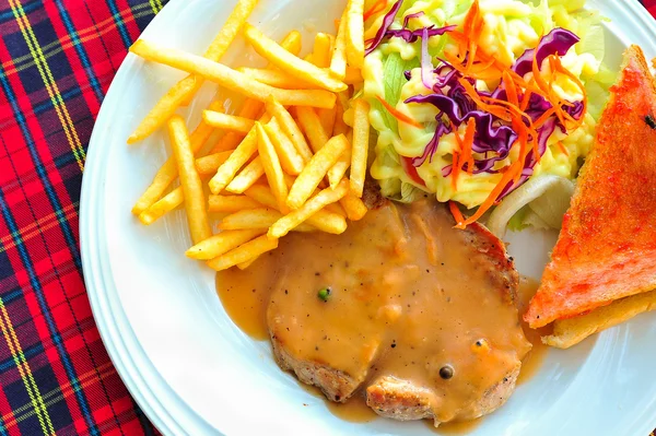 Жареный стейк, картофель фри, тосты и салат — стоковое фото